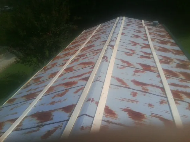 Rusted metal roof panels with new wood purlins before replacement — Storm Damage Roof Repair in Crescent City by Roofing Brothers