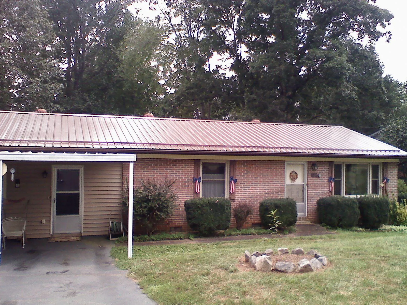 Bronze metal roof and carport on a brick ranch home — Roof Repair work by our crew in Crescent City